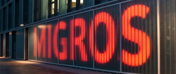 Migros Waadt Aussenmauer mit Logo Migros Waadt Aussenmauer mit Logo